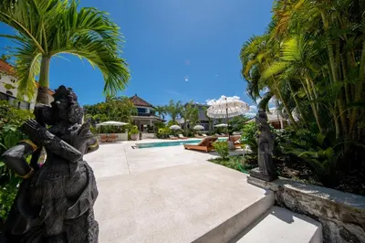 a garden with palm trees and a swimming pool at Three-Bedroom Pool Villa at Anwa Residences in Canggu