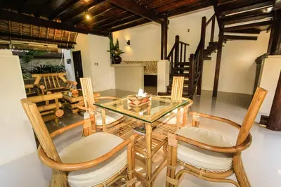 a dining room with a glass table and chairs at Radiant Jepun Villa in Legian