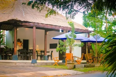 a restaurant with tables and chairs and umbrellas at Radiant Jepun Villa in Legian