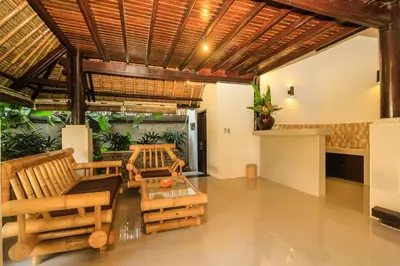 a living room with chairs and a table at Radiant Jepun Villa in Legian