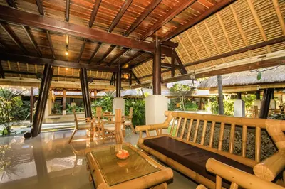 a pavilion with a table and chairs and a bench at Radiant Jepun Villa in Legian