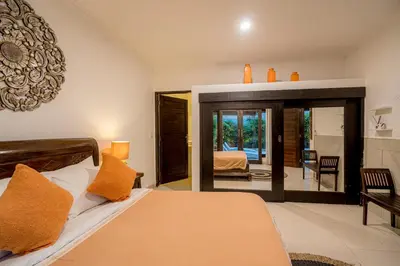 a bedroom with a bed and a mirror at Sari Temuku Villa in Seminyak