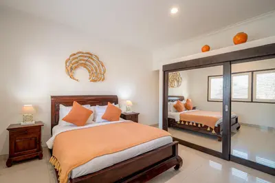a bedroom with two beds and a large mirror at Sari Temuku Villa in Seminyak