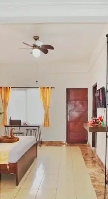 a bedroom with a bed and a ceiling fan at Balian Surf Club in Legian