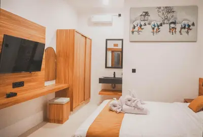 a bedroom with a bed and a flat screen tv at Budha Manis Villa in Kerobokan