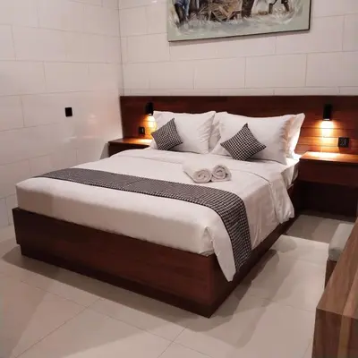 a bedroom with a large bed with two night stands at Budha Manis Villa in Kerobokan