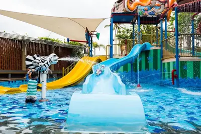a child playing on a water slide at a water park at Grand Mirage Resort & Thalasso Bali - All Inclusive in Nusa Dua