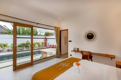 a bedroom with a bed and a large window at Cosy 2bd Chic Villa with Private Pool in Central Location in Kerobokan