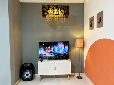 a flat screen tv sitting on top of a white cabinet at Villaok in Kuta