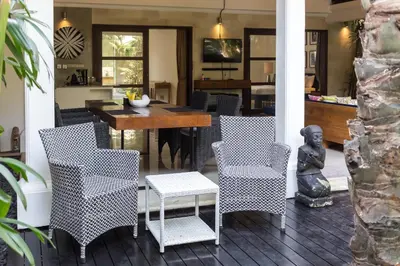 a dining room with a table and chairs and a kitchen at Villa Cantik in Canggu