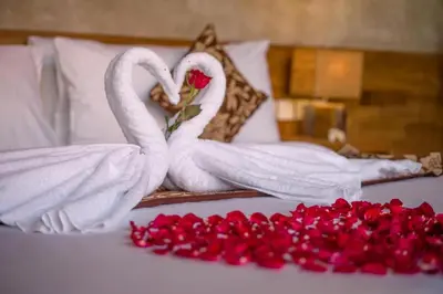 two white swans making a heart on a bed with red pedals at Mezzanine Industrial 1 Bedroom Private Villa in Seminyak in Seminyak