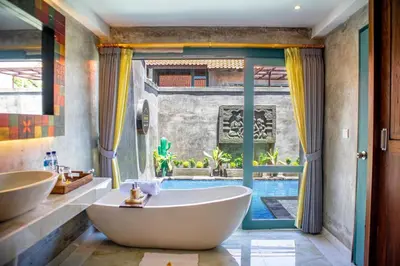 a bathroom with a tub and a swimming pool at Mezzanine Industrial 1 Bedroom Private Villa in Seminyak in Seminyak