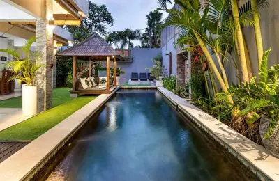 an infinity pool in a backyard with a gazebo at Buddha Beach Villa Seminyak in Seminyak