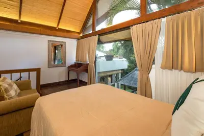 a bedroom with a bed and a couch and a window at Buddha Beach Villa Seminyak in Seminyak