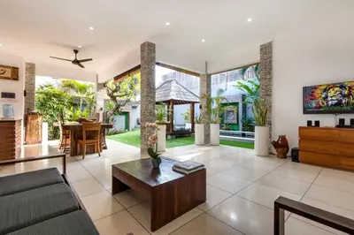 a living room with a couch and a table at Buddha Beach Villa Seminyak in Seminyak