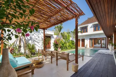 an outdoor patio with a wooden pergola and a swimming pool at Villa Pawikan Gorgeous 4 beds villa in the heart of Seminyak in Seminyak