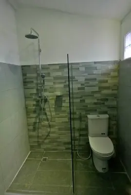 a bathroom with a shower with a toilet and a glass door at Private villa with pool near 66 in Seminyak in Seminyak