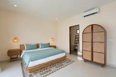 a bedroom with a large bed and an ar doorway at Roselle Villa by Betterplace in Canggu