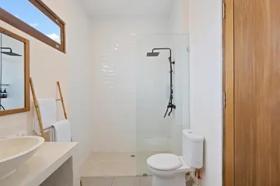 a bathroom with a shower and a toilet and a sink at Roselle Villa by Betterplace in Canggu