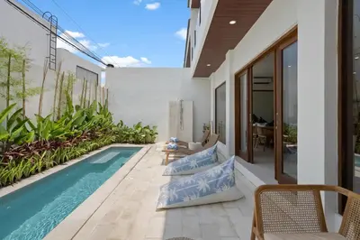 an outdoor patio with a swimming pool and a villa at Roselle Villa by Betterplace in Canggu