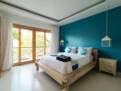 a bedroom with a large bed with blue walls at New Villa Lotus 2BR Private Pool Villas in Seminyak
