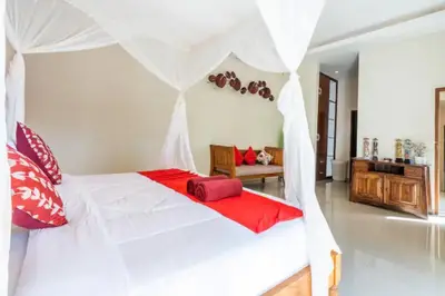 a bedroom with a white bed with red pillows at New Villa Lotus 2BR Private Pool Villas in Seminyak