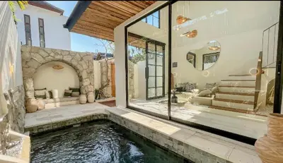 a house with a swimming pool in front of a house at VILLA HAWILA 2BR OBEROI SEMINYAK PRIME LOCATION - No FLOOD in Seminyak