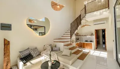 a living room with a couch and a stair case at VILLA HAWILA 2BR OBEROI SEMINYAK PRIME LOCATION - No FLOOD in Seminyak