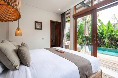 a bedroom with a large bed and a pool at Luxury 3bd Villa 5 Min From Berawa Beach in Canggu