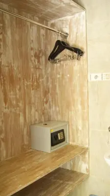 a microwave sitting on a shelf in a bathroom at Sugiras Living in Denpasar