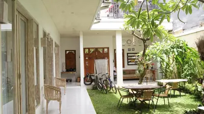 a patio with a table and chairs and a table at Sugiras Living in Denpasar
