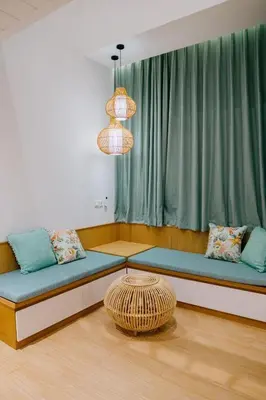 a room with couches and a table in front of a window at Casa Amarta Canggu - Boutique Lofts & Detox SPA in Canggu