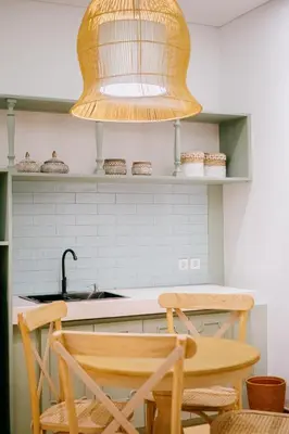 a kitchen with a table and two chairs and a light fixture at Casa Amarta Canggu - Boutique Lofts & Detox SPA in Canggu
