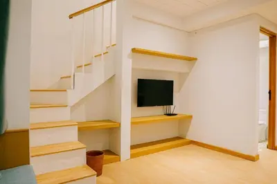 a room with a staircase with a television and a stair case at Casa Amarta Canggu - Boutique Lofts & Detox SPA in Canggu