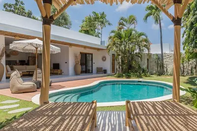a swimming pool with two chairs and a house at Villa Alamanda Livia Seminyak Design spacious 2bdr and private pool in Seminyak