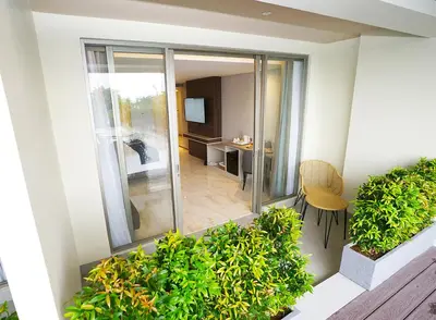 an apartment with a balcony with a table and chairs at Platinum Hotel Jimbaran Beach Bali in Jimbaran