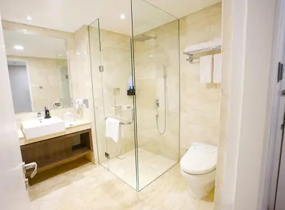 a bathroom with a shower and a toilet and a sink at Platinum Hotel Jimbaran Beach Bali in Jimbaran