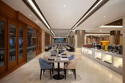 a restaurant with tables and chairs and a bar at Platinum Hotel Jimbaran Beach Bali in Jimbaran