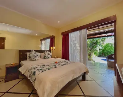 a bedroom with a bed and a large window at Villa Yauda - Charming 3BR w/Private pool & Garden in Seminyak