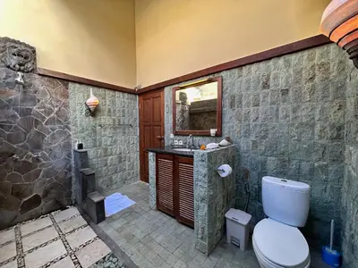 a bathroom with a shower and a toilet and a sink at Villa Yauda - Charming 3BR w/Private pool & Garden in Seminyak