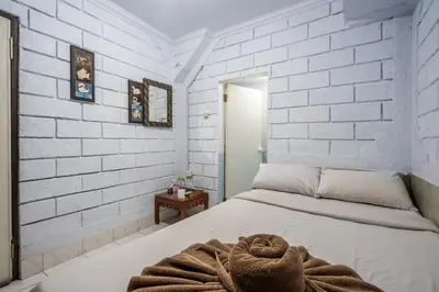 a bedroom with white brick walls and a bed at Ammara Legian By Vilarisi - 8 Minute Walk To The Beach in Legian