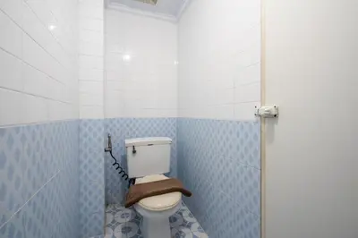 a bathroom with a toilet with blue tiled walls at Ammara Legian By Vilarisi - 8 Minute Walk To The Beach in Legian