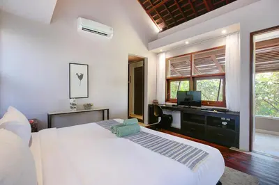 a bedroom with a bed and a desk with a television at Villa Giva Seminyak - 2 Bedrooms Seminyak in Seminyak