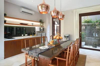 a kitchen with a large table with wooden chairs at Villa Giva Seminyak - 2 Bedrooms Seminyak in Seminyak