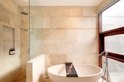a bathroom with a tub and a glass shower at Villa Giva Seminyak - 2 Bedrooms Seminyak in Seminyak