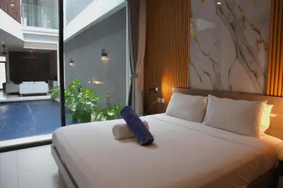 a bedroom with a bed with a stuffed animal on it at Berawa Bali Beach Villas Canggu in Canggu