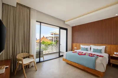 a bedroom with a large bed and a balcony at Sayang Villa Bali in Kerobokan
