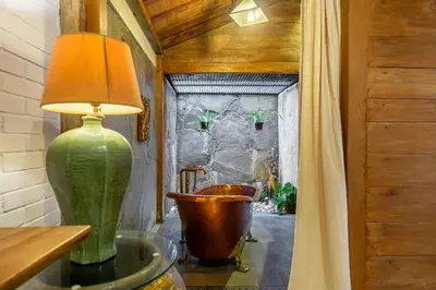 a green vase sitting on a glass table next to a tub at Villa Arumanis in Canggu