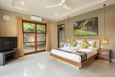 a bedroom with a bed and a tv in a room at Villa 500m2 with 14m Pool, BBQ, Pinball - Seminyak in Seminyak