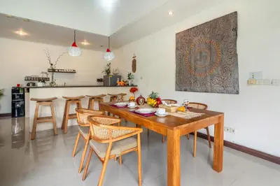 a kitchen and dining room with a wooden table and chairs at Villa Ricci Seminyak in Kerobokan